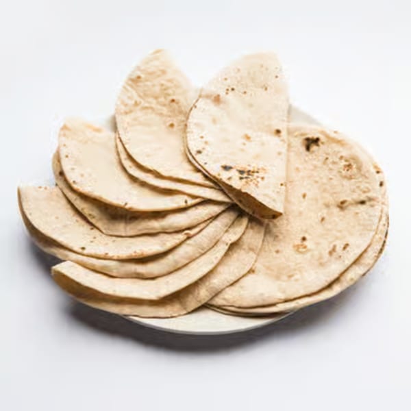 A plate of freshly made, folded Indian flatbreads, likely rotis or chapatis, on a white background.