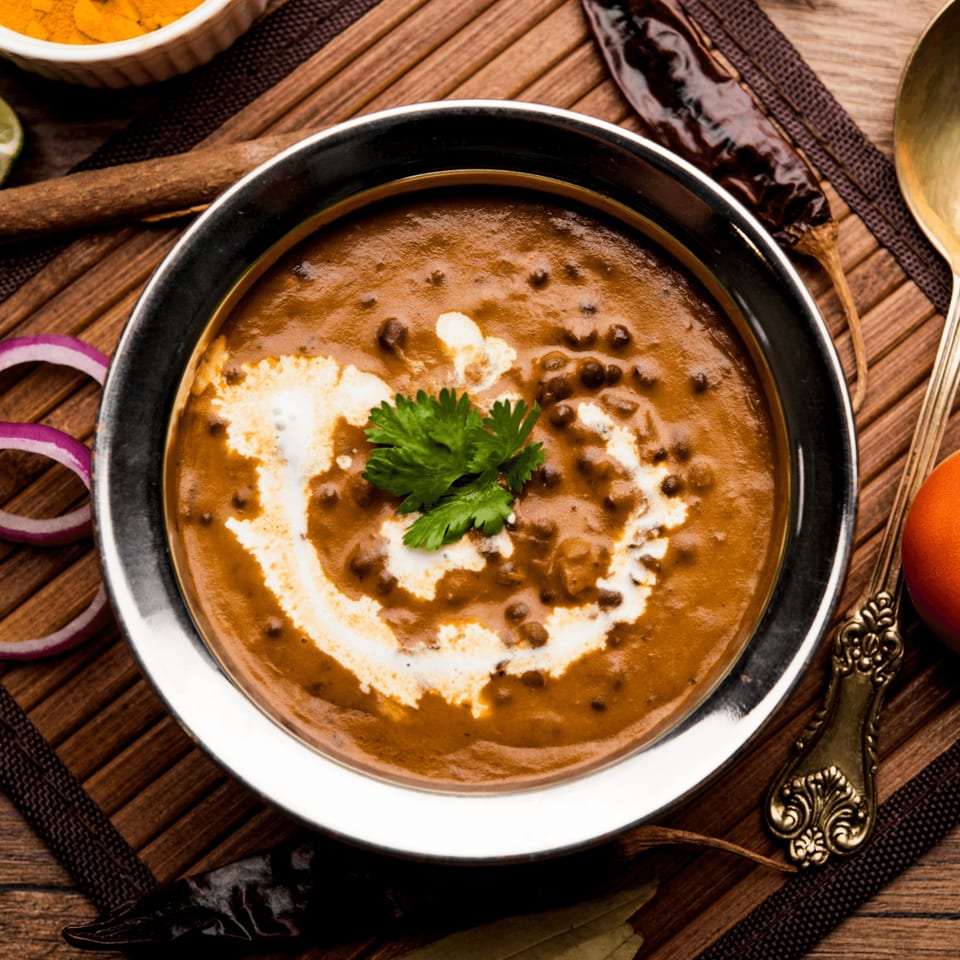 A bowl of creamy Indian Dal Makhani, garnished with fresh cilantro and a swirl of cream.